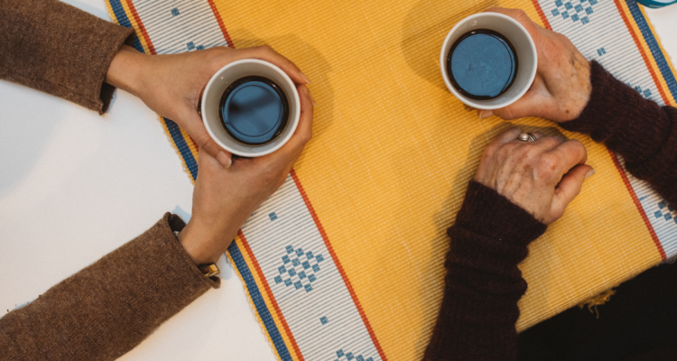 Händer omfamnar kaffekopp